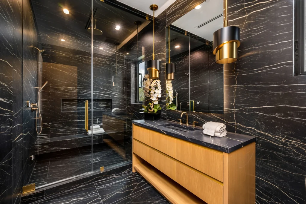 Luxurious custom-designed bathroom with black marble and gold fixtures in Philadelphia